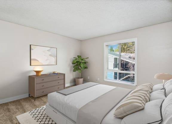 Model bedroom with a large bed next to a window