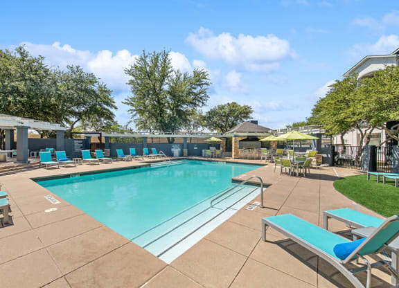 Community Swimming Pool with Pool Furniture at Allure North Dallas Apartments in Dallas, TX.