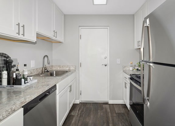 Model Kitchen with White Cabinets and Wood-Style Flooring at Stone Ends Apartments in Stoughton, MA.