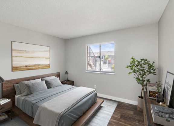 West Las Vegas, NV Apartments - Accent on Rainbow - Primary Bedroom With Wood Frame Bed, Gray Bedding, Matching Nightstands, Wall Art, And Window Blinds