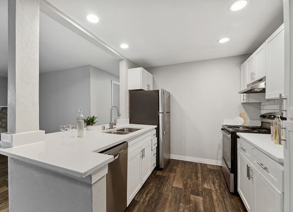 Model Kitchen with White Cabinets and Wood-Style Flooring at Central Flats Apartments in Kent, WA.