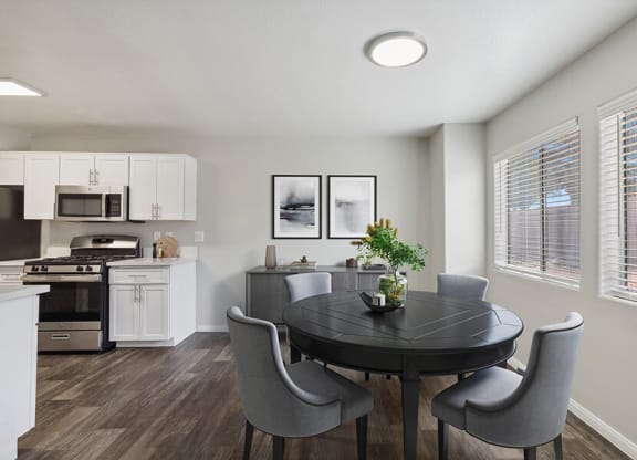 Model Dining Room with Wood-Style Flooring and View of Kitchen at Loma Vista Apartments in Las Vegas, NV.