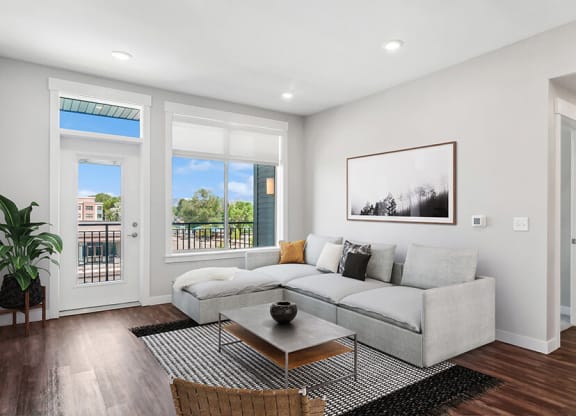 Model Living Room with Wood-Style Flooring and Patio Accessibility at Seven Skies Apartments located in Sandy, UT.