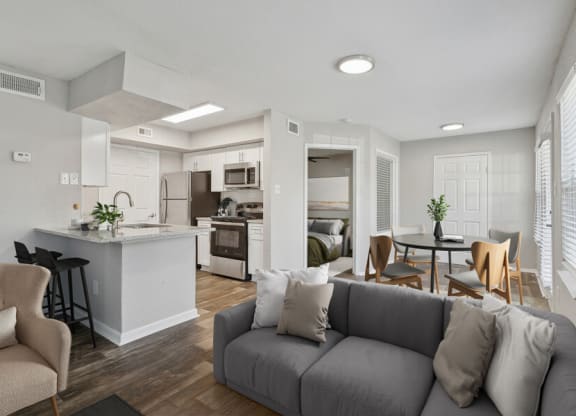 the living room and kitchen of an apartment with a couch and a table