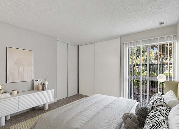 Model Bedroom with Carpet and Patio Accessibility at Madison Park Apartments located in Anaheim, CA.