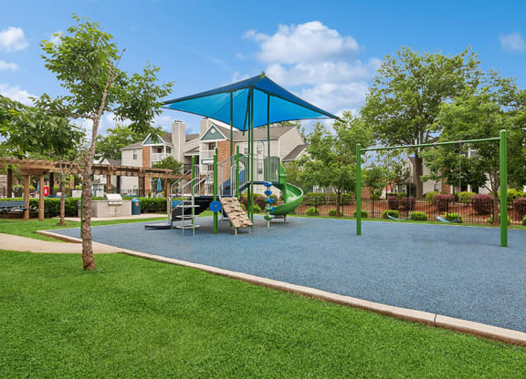 Community Playground with a Slide, Blue Canopy and Swing Set at Park 2300 Apartments in Charlotte, NC.