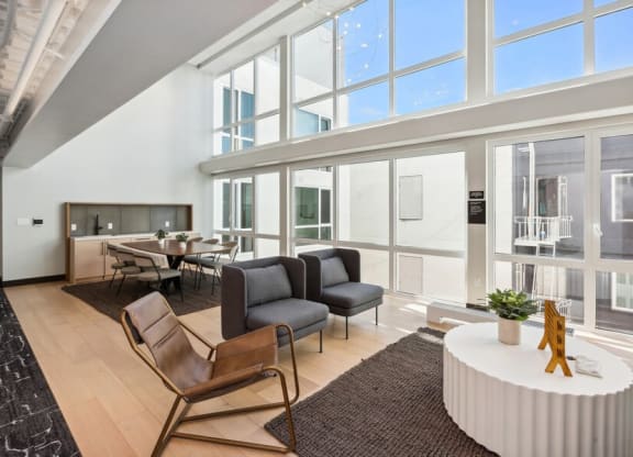 Indoor lounge and dining area with large sun windows at TL Residences