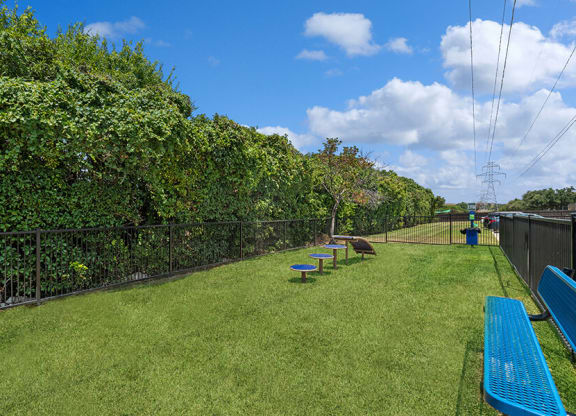 Community Dog Park with Agility Equipment and Bench at Bridges at Deer Run Apartments in Dallas, TX.