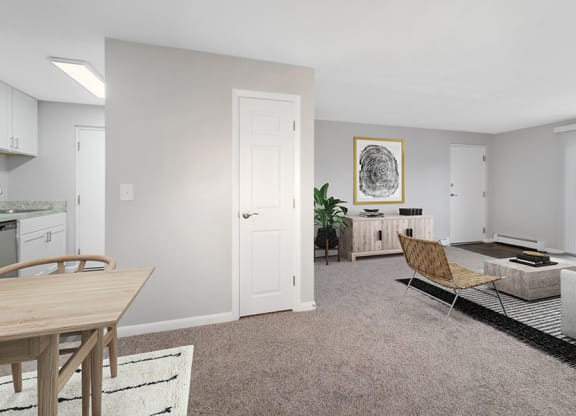 Model Living Room with Carpet and Patio Accessibility at Stone Ends Apartments in Stoughton, MA.