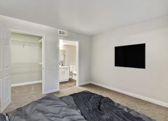 Model bedroom with a bed and a television on the wall