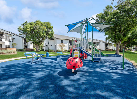 Community Playground with Slide and Blue Canopy at Rosehill Preserve Apartments in Orlando, FL.
