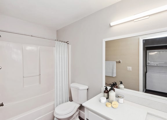 Model Bathroom with White Cabinets, Wood-Style Flooring and Shower/Tub at Vue at Baymeadows Apartments in Jacksonville, FL.