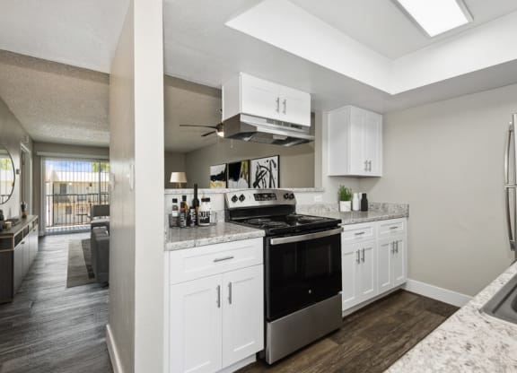 a kitchen with white cabinets and a black stove top oven at Villages at Metro Center, Arizona, 85051