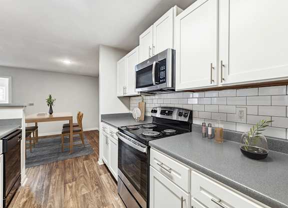 Model Kitchen with White Cabinets and Wood-Style Flooring at Lake Cameron Apartments located in Apex, NC.