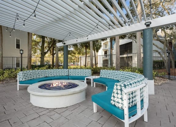 Covered Outdoor Fire Pit Area with Cushioned Patio Furniture at Caribbean Breeze Apartments in Tampa, FL.