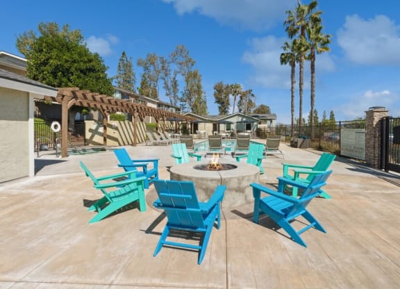 Community Fire Pit surrounded with Blue Chairs at Forest Park Apartments in El Cajon, CA.
