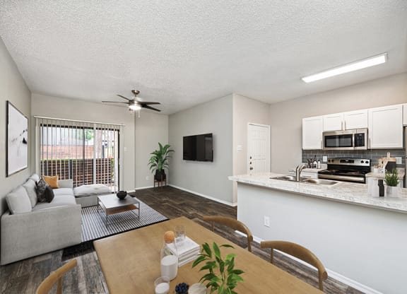 Model Dining Room and Kitchen Area with View of Living Room at Dallas North Park Apartments in Dallas, TX.