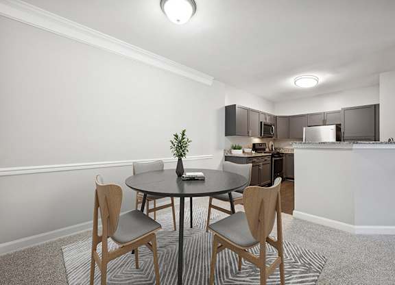 Model Dining Room with Carpet and View of Kitchen at Dulles Green Apartments located in Herndon, VA.