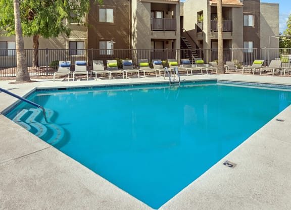 Community Swimming Pool with Pool Furniture at Saddle Ridge Apartments in Tucson, AZ.