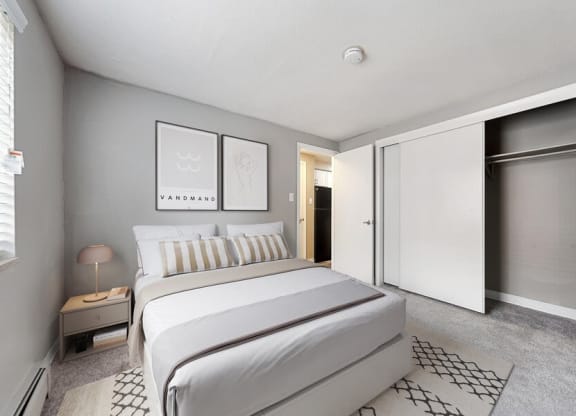 Model bedroom with sliding door closet at Esprit Cherry CreekApartments in Glendale, CO