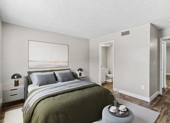 Model Bedroom with Wood-Style Flooring and Attached Bathroom at Meadow Ridge Apartments in Las Vegas, NV.
