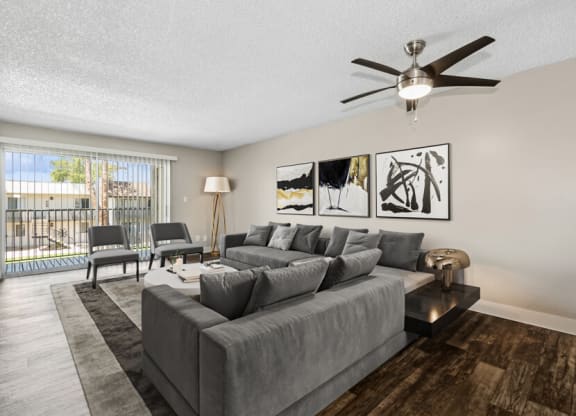a living room with a large couch and a ceiling fan at Villages at Metro Center, Phoenix