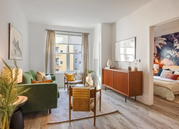 Model living room with a lot of pillows and chairs and a window