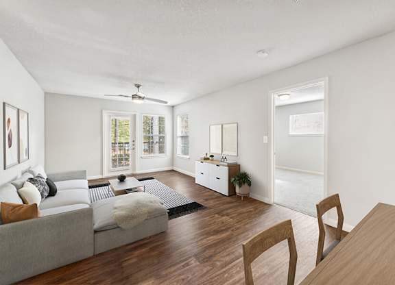 Model Living Room with Wood-Style Flooring and Patio Accessibility at Lake Cameron Apartments located in Apex, NC.