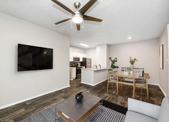 Model Living Room and Dining Room Area with Wood-Style Flooring at Dallas North Park Apartments in Dallas, TX.