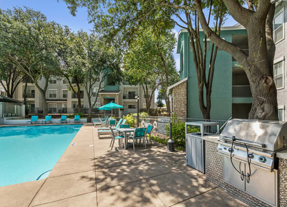 Community Swimming Pool with Pool Furniture at Essence Apartments in Dallas, TX.