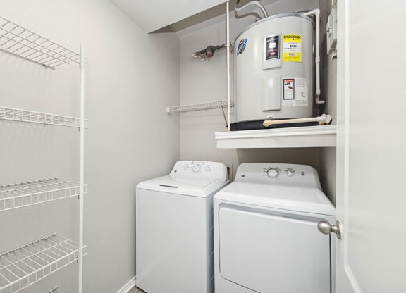 Model Laundry Room with Wood-Style Flooring, Water Heater & Storage Shelves at Allure North Dallas Apartments located in Dallas, TX.