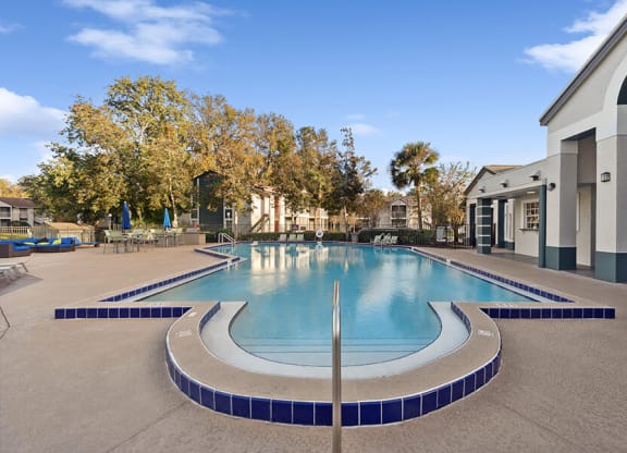 Community Swimming Pool with Pool Furniture at Vue at Baymeadows Apartments in Jacksonville, FL.