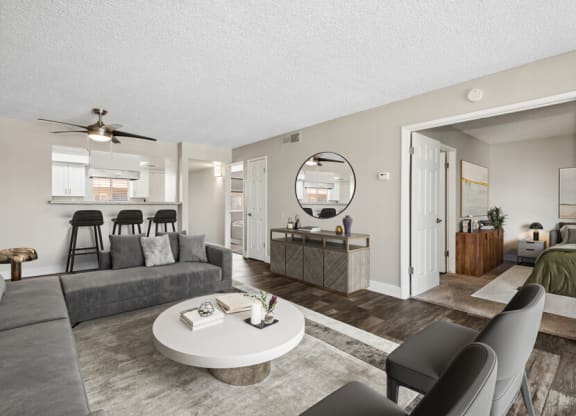 Model apartment living room with a couch a coffee table and a kitchen at Villages at Metro Center, Phoenix, 85051