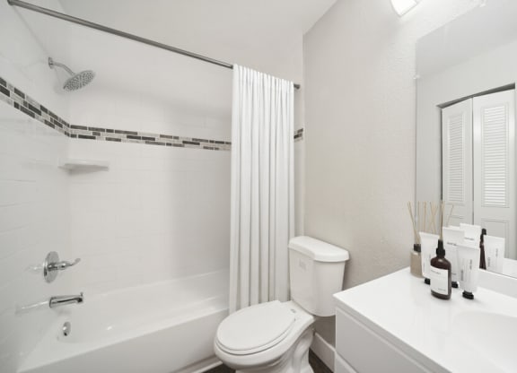 a bathroom with a white toilet sitting next to a bath tub