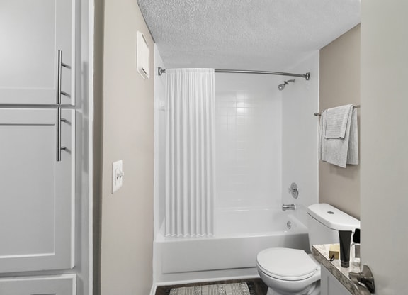 Model Bathroom with White Cabinets, Wood-Style Flooring and Shower/Tub at Abbington Heights Apartments in Antioch, TN.