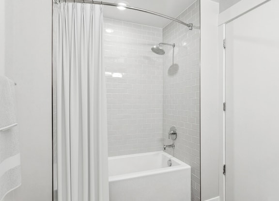 Model Bathroom with Wood-Style Flooring and Shower/Tub at Seven Skies Apartments located in Sandy, UT.