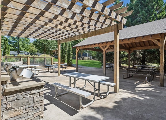Outdoor BBQ Area with Canopy and Picnic Tables at Lakeside Retreat Apartments located in Peachtree Corners, GA.