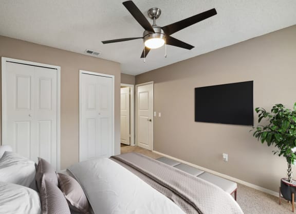 Model bedroom with a bed and a ceiling fan at Vue at Baymeadows Apartments in Jacksonville, Florida