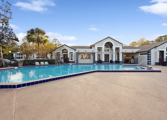 Community Swimming Pool with Pool Furniture at Vue at Baymeadows Apartments in Jacksonville, FL.