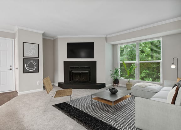 Model Living Room with Fireplace and Carpet at Arbor Village Apartments in Charlotte, NC.