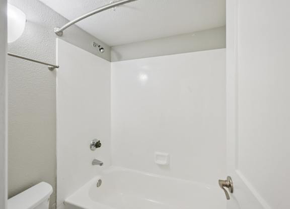 Model white bathroom with a tub, toilet and sink.