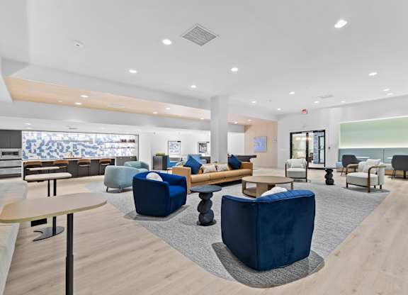 A spacious waiting area with blue chairs and a wooden floor.