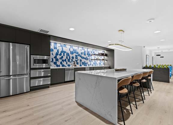 A modern kitchen with a marble island and stainless steel appliances.