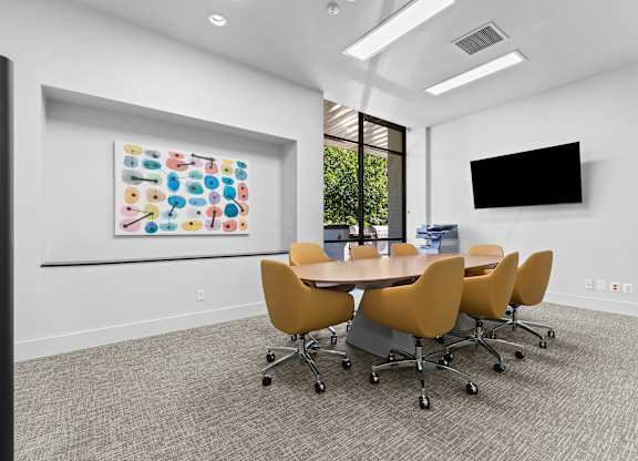 A conference room with a large table and chairs.