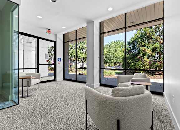 A room with a glass wall and a table with chairs.