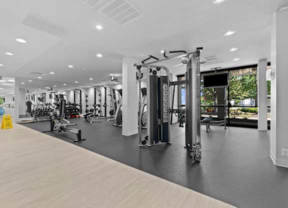 A gym with a variety of equipment including treadmills, weights, and exercise machines.