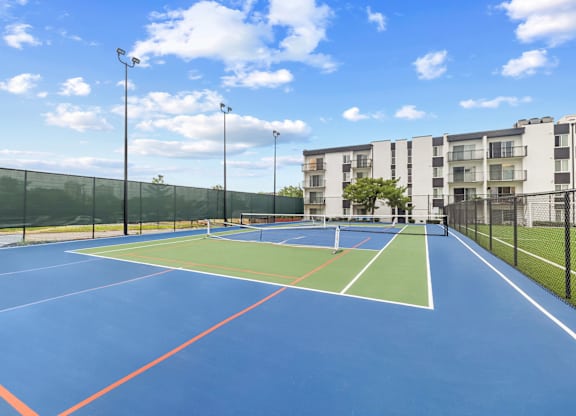 A tennis court with a blue surface and red lines.