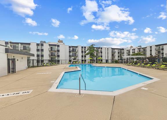 A large swimming pool in front of apartment buildings.