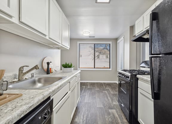 Model Kitchen with White Cabinets and Wood-Style Flooring at Spring Parc Apartments in Silver Spring, MD.