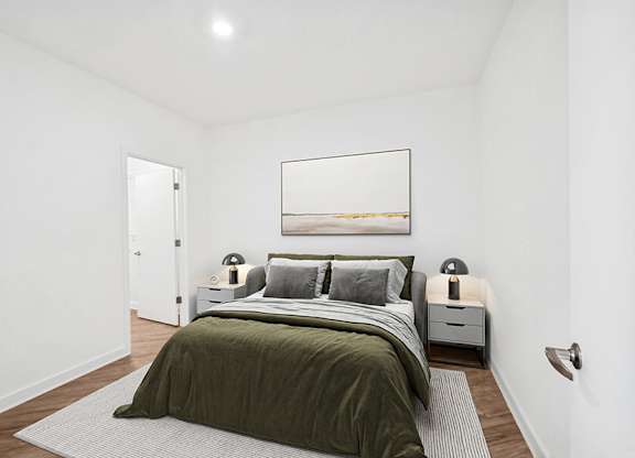 Model Bedroom with Wood-Style Flooring and attached Bathroom at Stella Apartments located in New Carrollton, MD.